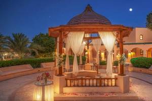 Drei-Ecken-Rihana-Resort-Garten-Pavillon, der nachts mit Blumen und Lichtern dekoriert ist.