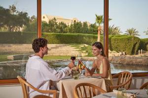 Paar genießt Mahlzeit mit Blick auf Hotelpool im Three Corners Rihana Resort