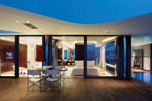 Innenansicht der Suite im Elounda Beach Hotel & Villas mit Esstisch und Blick auf das Bett.