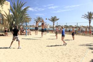 Gruppe junger leute spielt beach volleyball im dreiecks-rihana-resort