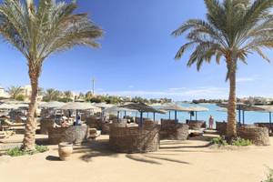 Drei-Ecken-Rihana-Resort-Strand mit Sonnenschirmen und Palmen