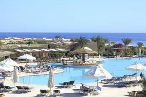 Außenbereich des Three Corners Fayrouz Plaza Beach Resort mit Pool, Liegestühlen und Sonnenschirmen.