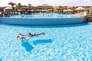 Ein Paar liegt auf Schwimmringen im Pool des Three Corners Fayrouz Plaza Beach Resorts.
