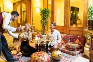 Ein Hotelmitarbeiter serviert ein Paar im Drei Ecken Fayrouz Plaza Strand Resort.