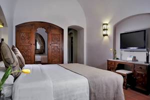 Schlafzimmer im Mövenpick Resort Sharm el Sheikh mit einem Bett, einem Fernseher und einem Schreibtisch.