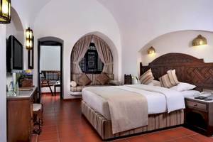Zimmer im Mövenpick Resort Sharm el Sheikh mit großem Bett, Sofa und Fernseher