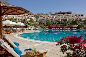 Außenpool des Mövenpick Resort Sharm el Sheikh mit Loungeliegen und Sonnenschirmen