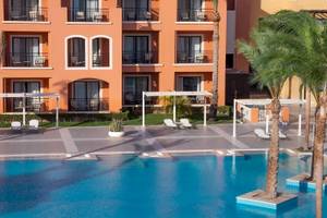 Außenbereich des JAZ Neo Dar El Madina Hotels mit Swimmingpool und Sonnenliegen.