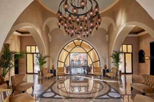 Hotellobby des JAZ Neo Dar El Madina mit einem großen Kronleuchter und Möbeln