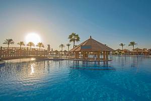Außenpool im Sunrise Royal Makadi Resort mit Sonnenuntergang im Hintergrund.