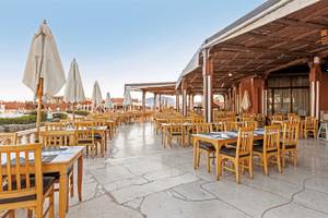 Außenbereich des Restaurants im Sunrise Royal Makadi Resort mit vielen Tischen und Stühlen.