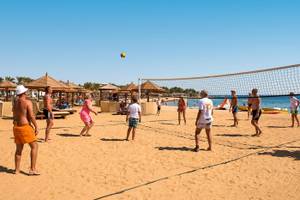 Beachvolleyball-Spiel am Sunrise Royal Makadi Resort mit Teilnehmern und einem Ball in der Luft.