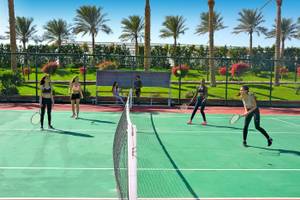 Tennisspiel im Sunrise Royal Makadi Resort mit Spielern und Zuschauern im Freien.