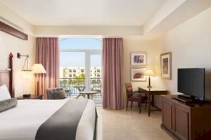 Hotelzimmer im Wyndham Garden Salalah Mirbat mit Balkon, Fernseher und Schreibtisch.