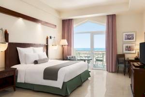Zimmer im Wyndham Garden Salalah Mirbat Hotel mit Meerblick und Balkon.