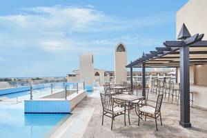Außenterrasse mit Swimmingpool und Tischen des Steigenberger Aqua Magic Hotels.