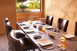 Ein elegantes Esszimmer im Anantara The Palm Dubai Resort mit gedecktem Tisch und Kerzen.