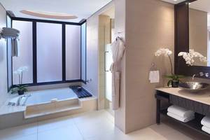 Badezimmer im Anantara The Palm Dubai Resort mit Badewanne, Waschbecken und Spiegel.