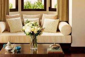Wohnzimmer im Anantara The Palm Dubai Resort mit Couch und Blumenvase auf dem Tisch