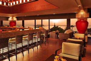 Innenansicht der Bar im Anantara The Palm Dubai Resort mit Blick auf den Ozean und roten Vasen.