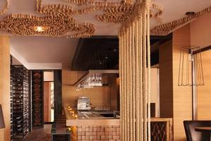 Innenansicht der Bar im Anantara The Palm Dubai Resort mit Holzelementen, einer Theke und einer Deckengestaltung aus Korken.