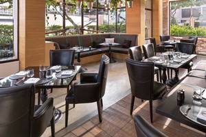 Innenansicht des Restaurants im Anantara The Palm Dubai Resort mit schwarzen Möbeln und Tischdekoration.