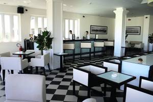 Rezeption im Boutique Hoi An Resort mit schwarz-weißem Boden und weißen Möbeln.