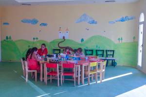 Spielzimmer für Kleinkinder im Cleopatra Luxury Beach Resort mit bunten Wandmalereien und Tischen.