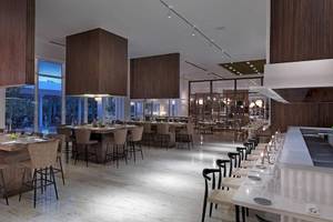 Innenansicht des Restaurants im Melia Caribe Beach Resort mit Holzelementen und runden Tischen.