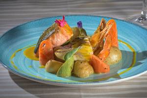 Fischgericht im Atrium Palace Thalasso Spa Resort & Villas mit Lachs, Garnelen, Kartoffeln und Karotten.