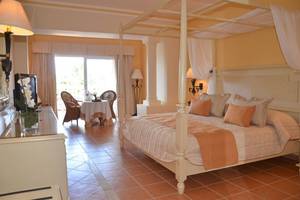 Schlafzimmer im Bahia Principe Grand Jamaica Hotel mit vierpfostenbett und Tageslicht.