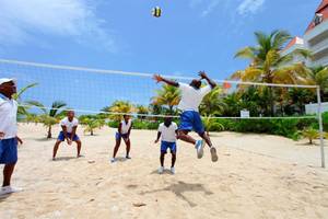 Spieler spielen Beachvolleyball am Strand vor dem Bahia Principe Grand Jamaica Hotel