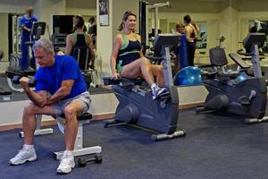 Fitnessstudio mit M�ännern und Frauen auf Stepper und Gewichtstraining