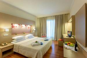 Marianna Palace Hotelzimmer mit Doppelbett, Fernseher, Obst und Weinflasche auf Tisch