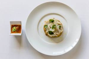 Eine vorspeise mit kalbsleber und roter zwiebel marinade auf einem weißen teller serviert