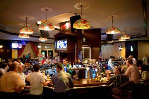 Barszene im Jumeira Rotana mit vielen Gästen, die an der Theke sitzen und trinken.
