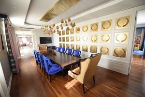 Das Speisezimmer im Land der Legenden Reich mit blauen Stühlen und goldenen Wandpaneelen.