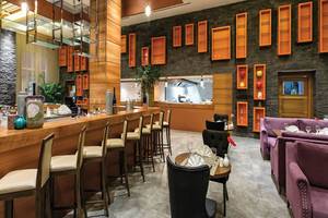 Restaurant im Land der Legenden Kingdom Hotel mit Bar, Stühlen und Tischen.