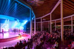 Ein Konzert auf der Bühne des Grand Sirenis Punta Cana Resorts, bei dem ein Publikum zuschaut.