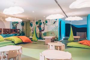 Kinderzimmer im Iberostar Waves Alcudia Park Hotel mit farbenfrohen Wänden, bunten Hängematten und gemütlichen Sitzecken.