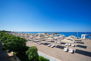 Strand des Club Nena mit vielen Sonnenliegen und Sonnenschirmen am Meer