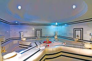 Innenansicht des Hamams im Club Nena Hotel mit weißen Marmorwänden und schwarzen Akzenten.