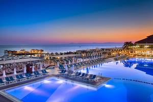 Abendlicher Pool im Club Nena Resort mit vielen Sonnenliegen und Blick aufs Meer