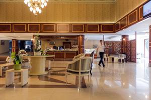 Lobby des Club Nena Hotels mit Empfangstresen, Stühlen und Tischen.