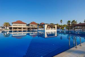 Ein blauer Swimmingpool mit einem großen Hotel im Hintergrund