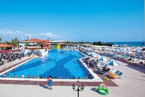 Aussicht auf den Swimmingpool des Club Nena Hotels mit vielen Gästen und Sonnenschirmen.