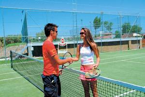 Tennisspieler beim Club Nena, ein Mann und eine Frau halten Tennisschläger und lächeln.