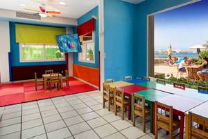 Kinderspielzimmer im Bull Dorado Beach & Spa Hotel mit bunten Möbeln und Fernseher.