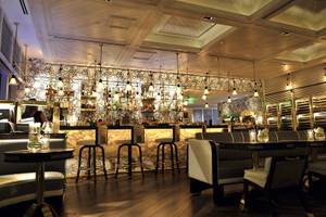 Innenansicht der Bar im Fontainebleau Miami Beach Hotel mit gemusterten Wänden und Holzboden.