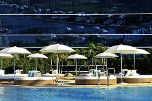 Pool-Loungebereich im Fontainebleau Miami Beach Hotel mit Sonnenschirmen und Liegestühlen.